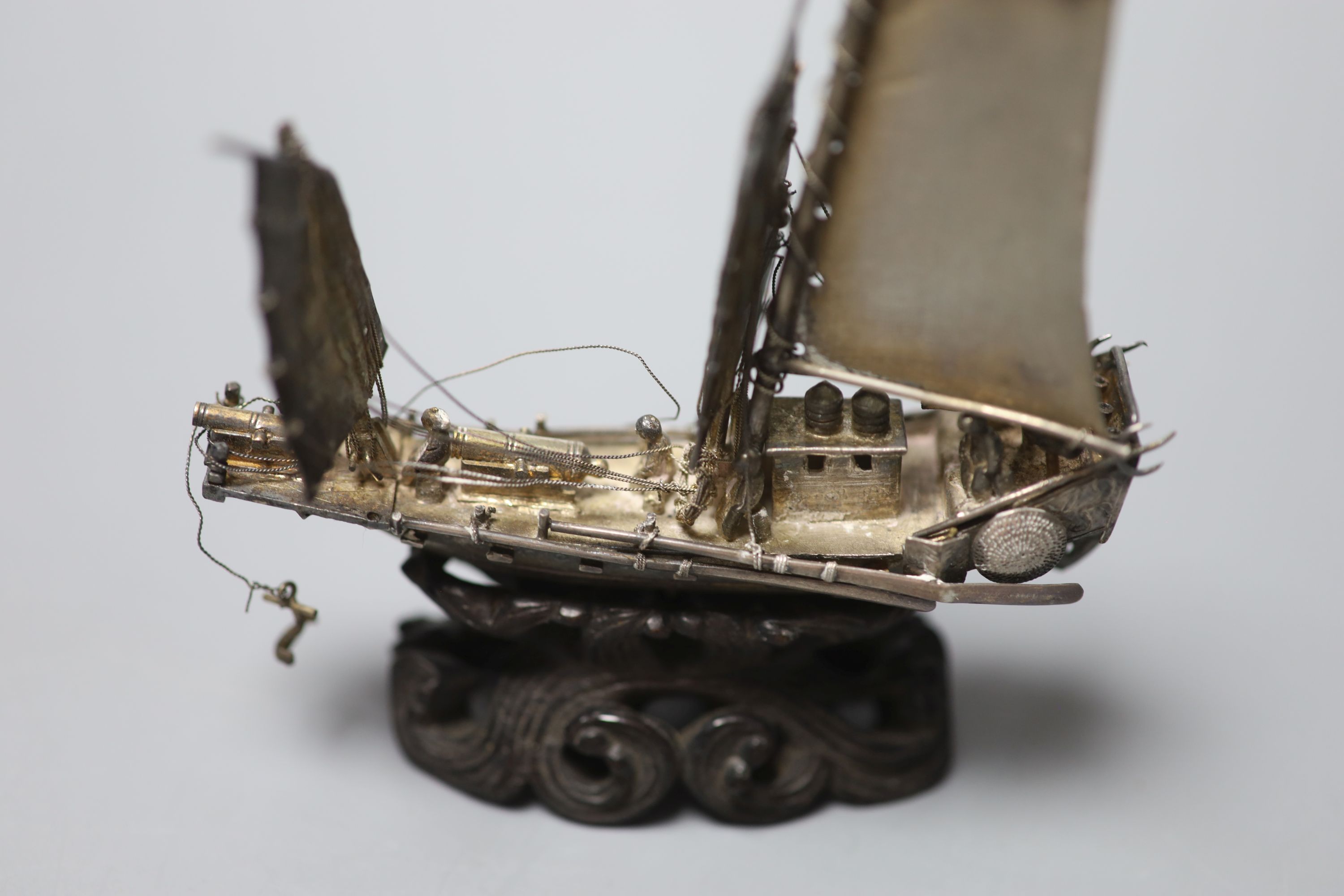 A Chinese white metal miniature model of a junk, 75mm, on wooden stand, in fitted box.